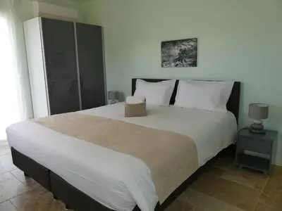 a bedroom with a large bed with white sheets and pillows at Maison d' Hôtes L'Aria Mezzana in Sainte-Lucie de Porto-Vecchio