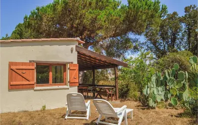 two chairs and a table in front of a house at Two-Bedroom Holiday Home In Calcatoggio in Calcatoggio