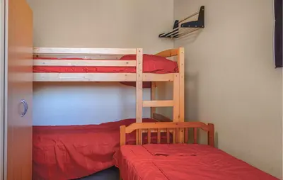 a bedroom with two bunk beds and a red bed at Two-Bedroom Holiday Home In Calcatoggio in Calcatoggio