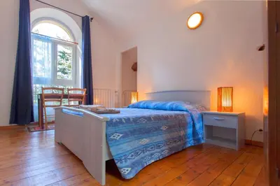 a bedroom with a bed and a table and a window at Casa Alta in Vizzavona