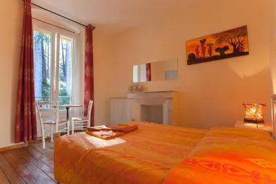 a bedroom with a bed and a table and a window at Casa Alta in Vizzavona