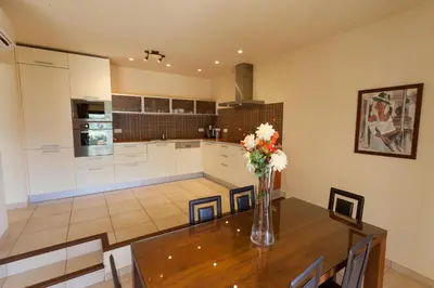 a kitchen with a table with a vase of flowers on it at Sci Albellu in Sagone
