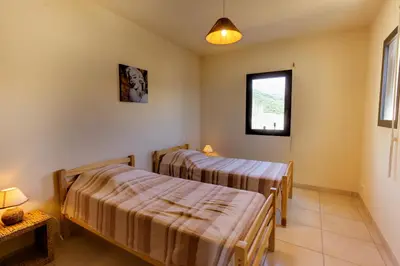 two beds in a room with a window at Sci Albellu in Sagone