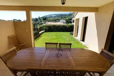 a dining room table with a view of a yard at Sci Albellu in Sagone