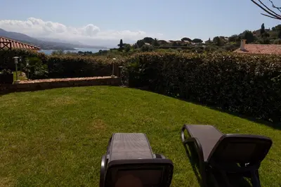 a bench sitting in the grass in a yard at Sci Albellu in Sagone