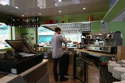 a man standing in a kitchen preparing food at Funtana a l'Ora in Porto Ota