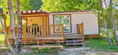 a wooden cabin with a large porch and a bench at Funtana a l'Ora in Porto Ota