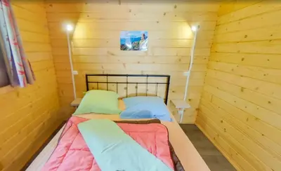 a small room with two beds in a log cabin at Funtana a l'Ora in Porto Ota