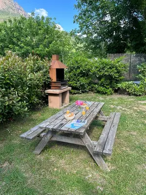 a picnic table in a yard with a grill at Funtana a l'Ora in Porto Ota