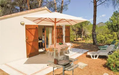 a patio with a table and an umbrella at Three-Bedroom Holiday Home In Calcatoggio in Calcatoggio