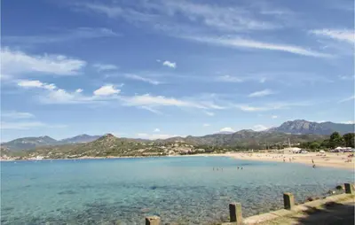 a view of a beach with people in the water at Three-Bedroom Holiday Home In Calcatoggio in Calcatoggio