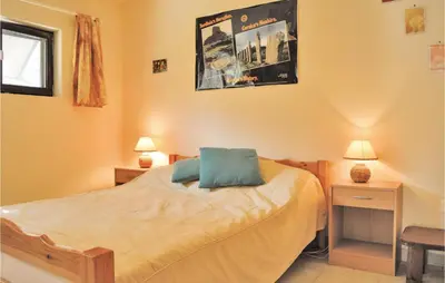 a bedroom with a bed with a blue pillow on it at Three-Bedroom Holiday Home In Calcatoggio in Calcatoggio