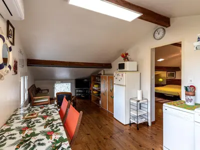 a kitchen and living room with a table and a refrigerator at Apartment Villa Volpajola by Interhome in Cervione