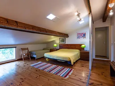 a bedroom with a bed in a room with wooden floors at Apartment Villa Volpajola by Interhome in Cervione