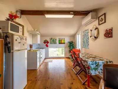 a kitchen with a table and a refrigerator at Apartment Villa Volpajola by Interhome in Cervione