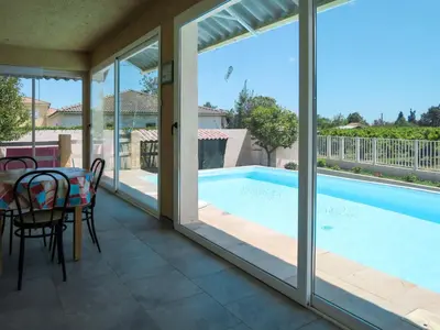 a patio with a table and chairs next to a swimming pool at Holiday Home La Cerisaie by Interhome in Santa-Lucia-di-Moriani