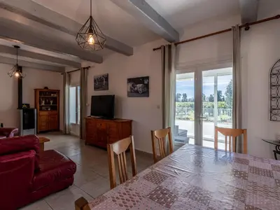 a living room with a dining room table and a television at Holiday Home La Cerisaie by Interhome in Santa-Lucia-di-Moriani