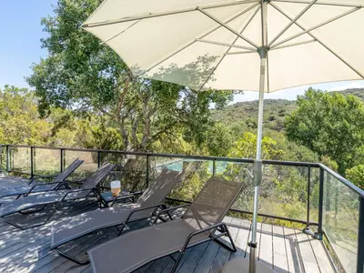 a group of chairs and an umbrella on a deck at Holiday Home Bruyères 1 by Interhome in Porticcio
