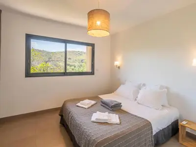a bedroom with a bed with two towels on it at Holiday Home Bruyères 1 by Interhome in Porticcio