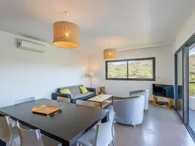 a dining room and living room with a table and chairs at Holiday Home Bruyères 1 by Interhome in Porticcio