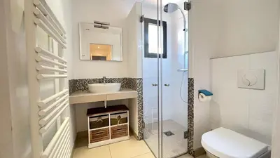 a bathroom with a shower and a sink and a toilet at Villa Santa Giulia, vue panoramique sur la mer, 900 m de la plage in Porto-Vecchio