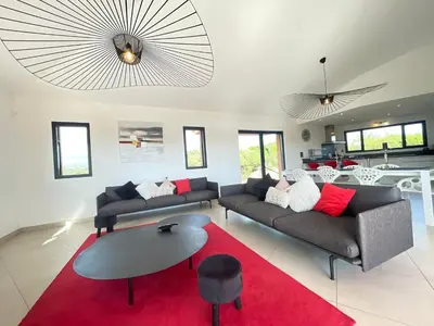 a living room with two couches and a red rug at Villa Santa Giulia, vue panoramique sur la mer, 900 m de la plage in Porto-Vecchio