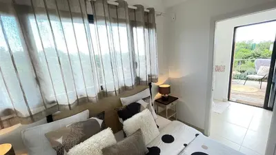 a living room with a couch and a large window at Villa Santa Giulia, vue panoramique sur la mer, 900 m de la plage in Porto-Vecchio