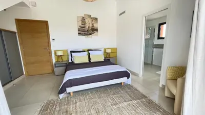 a bedroom with a bed and a couch in it at Villa Santa Giulia, vue panoramique sur la mer, 900 m de la plage in Porto-Vecchio