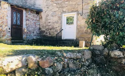 a door of a stone building with a stone wall at Bas De Maison in Olivese