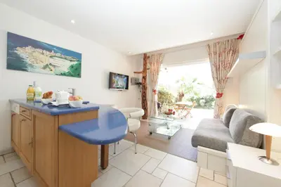a kitchen and living room with a blue table and a couch at Studio Cartarana in Bonifacio