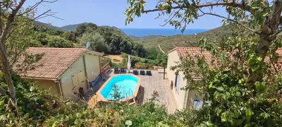 an outdoor swimming pool with a view of the ocean at Les Terrasses de Scaglioli in Villanova