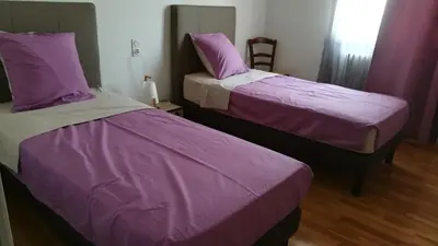 two beds in a room with purple sheets at Rinasce In Corsica in Poggio-di-Venaco