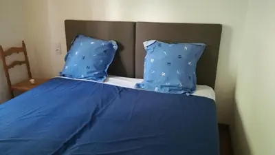 a bed with blue sheets and blue pillows at Rinasce In Corsica in Poggio-di-Venaco