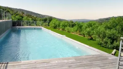 a large swimming pool in a yard with trees at Maison chaleureuse à Bonifacio, 90 m², piscine partagée in Conte