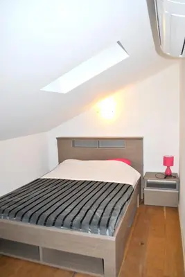 a bedroom with a bed in a attic at Maison chaleureuse à Bonifacio, 90 m², piscine partagée in Conte