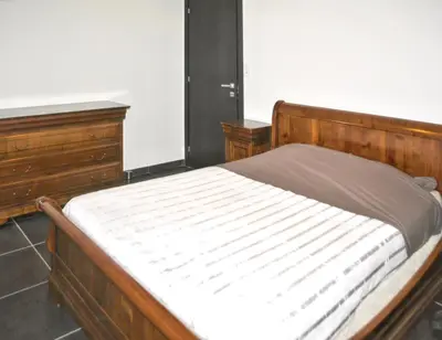 a bedroom with a wooden bed and two dressers at Maison chaleureuse à Bonifacio, 90 m², piscine partagée in Conte
