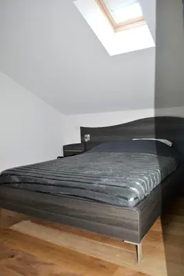 a black bed in a room with a window at Maison chaleureuse à Bonifacio, 90 m², piscine partagée in Conte
