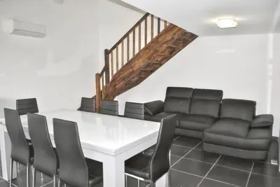 a dining room with a white table and leather chairs at Maison chaleureuse à Bonifacio, 90 m², piscine partagée in Conte