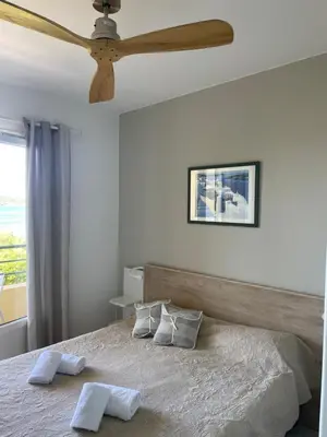 a bedroom with two beds and a tv on the wall at Hotel Thalassa in Cargèse