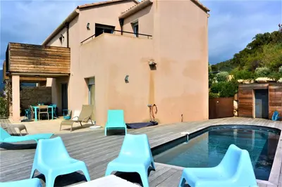 a villa with a swimming pool and blue chairs at COLOMBA in Conca
