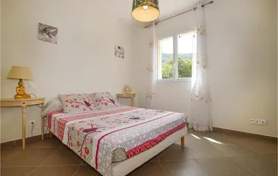 a bedroom with a bed and a window at Amazing Apartment In Petreto-Biccisano in Petreto-Bicchisano
