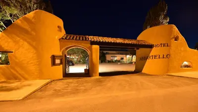 an entrance to a yellow building with an archway at Hôtel Abbartello in Olmeto