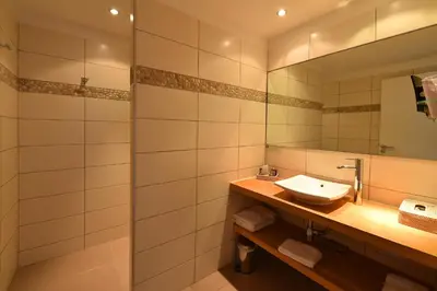 a bathroom with a sink and a mirror at Hôtel Abbartello in Olmeto