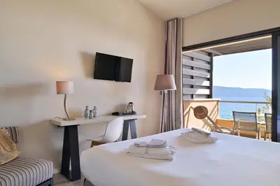 a hotel room with a bed and a balcony at Hôtel Abbartello in Olmeto