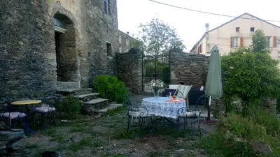 a patio with a table and chairs and an umbrella at Appartement 2 chambres A Casa De Giovanni à Pietra-di-Verde en Haute-Corse in Pietra-di-Verde