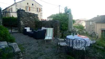 a garden with a table and chairs and a fence at Appartement 2 chambres A Casa De Giovanni à Pietra-di-Verde en Haute-Corse in Pietra-di-Verde