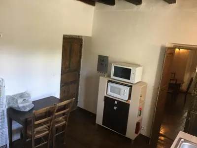 a small kitchen with a table and a microwave at Appartement 2 chambres A Casa De Giovanni à Pietra-di-Verde en Haute-Corse in Pietra-di-Verde