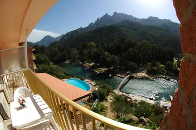 a balcony with a view of a river and mountains at Le Méditerranée in Porto Ota