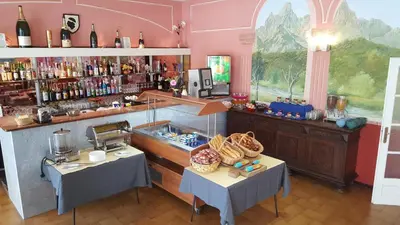 a room with two tables and a bar with wine bottles at Le Méditerranée in Porto Ota