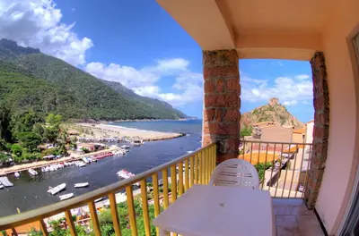 a balcony with a view of a river and mountains at Le Méditerranée in Porto Ota